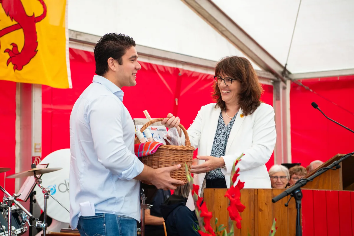 Gemeindepräsidentin Dr. Monika Keller (FDP) schenkt Matthias Müller einen Früchtekorb.